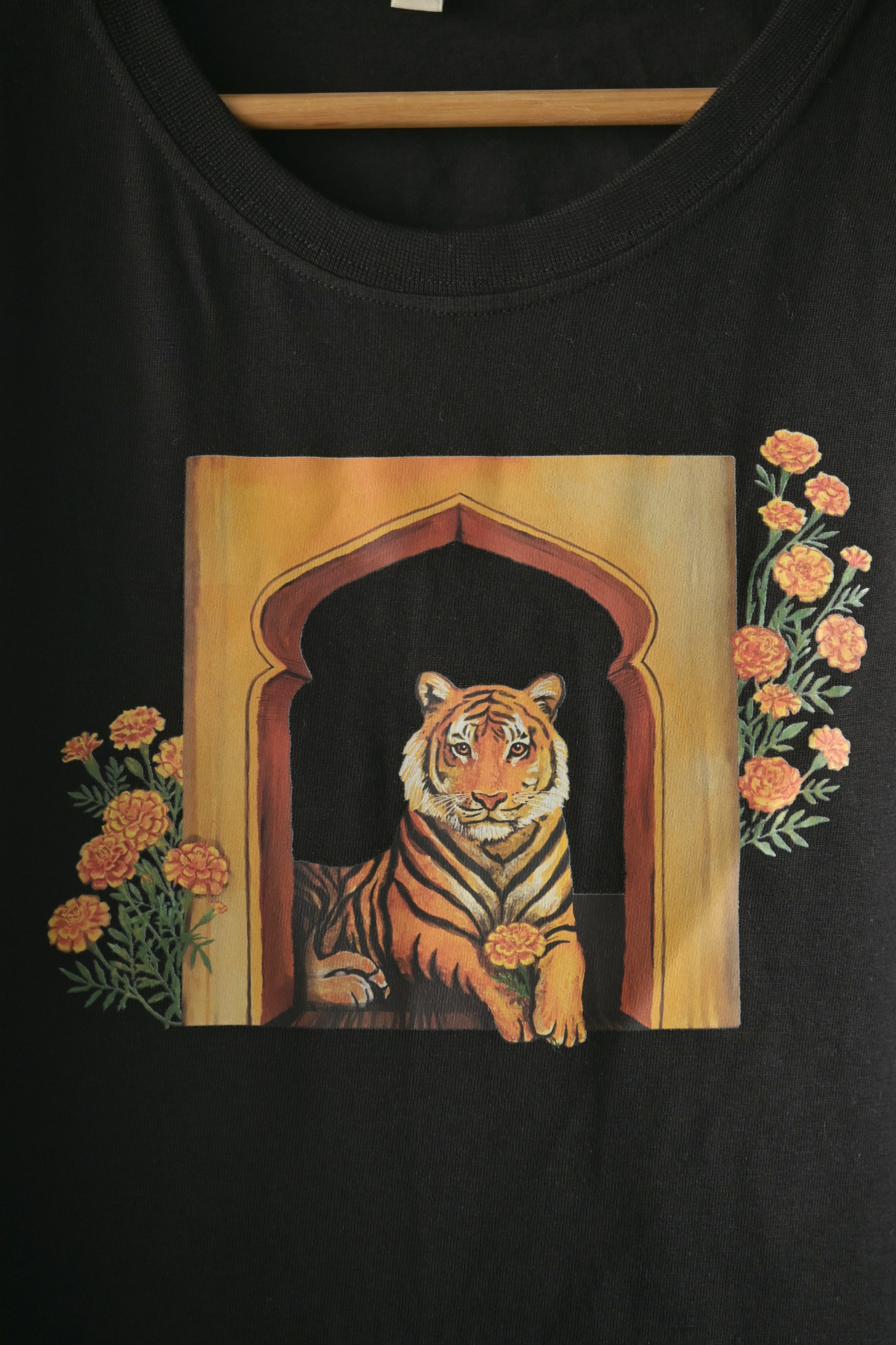 A tiger holds the marigold flower gently 🌼